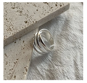 Close-up of S925 sterling silver multilayer woven ring on a textured stone surface