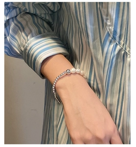 Détail d'un bracelet en perles d'argent S925 et perles d'eau douce porté au poignet