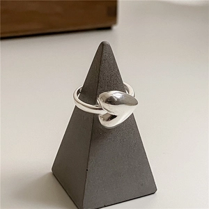 Polished S925 sterling silver heart ring on a minimalist geometric stand