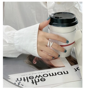 Detail of S925 sterling silver multilayer woven ring on hand with aesthetic fashion props