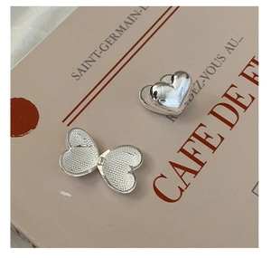 Detailed view of heart-shaped S925 sterling silver earrings with flip-open design and texture