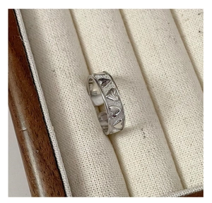 Detail of S925 sterling silver heart ring on a velvet stand inside a wooden box