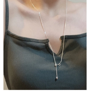 Detail of adjustable silver heart choker with tassel and sliding buckle on a model