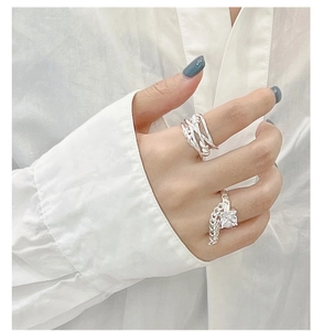 Macro detail of silver multi-layer woven ring and chain ring with square crystal