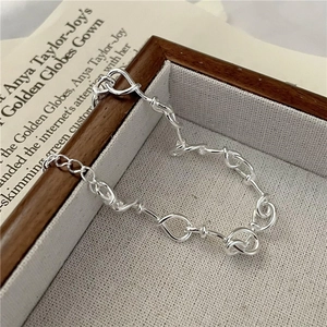 Minimalist 925 sterling silver twisted knot link bracelet displayed in a wooden jewelry box
