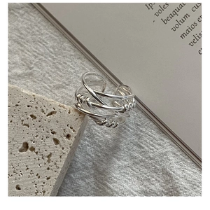 Detail of S925 sterling silver multilayer woven ring on a natural stone surface