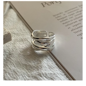Detailed macro shot of a S925 sterling silver multilayer woven ring on soft linen fabric