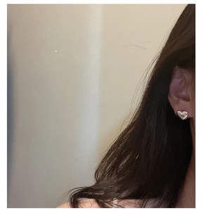 Polished S925 sterling silver heart-shaped stud earring worn by a model in soft light