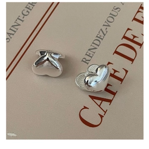 Close-up of heart-shaped 3D silver studs on a stylish vintage card background