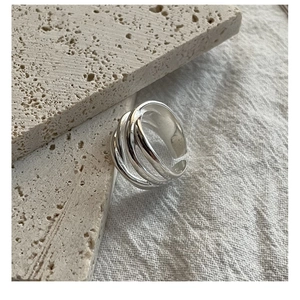 Detailed view of S925 sterling silver multilayer woven ring on stone background