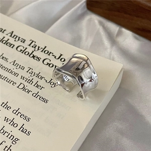 Polished S925 sterling silver wavy ring with irregular texture on white satin