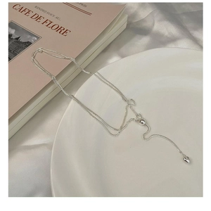 Detail of adjustable S925 sterling silver heart necklace on white ceramic tray