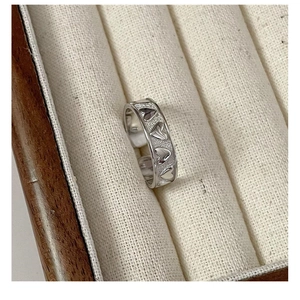 Detailed macro shot of S925 sterling silver ring with continuous heart relief patterns