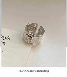Detail of vintage S925 silver wide band ring featuring hammered texture and gold heart