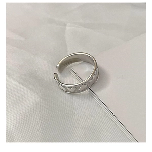 Detailed view of the S925 sterling silver ring featuring embossed heart patterns and texture