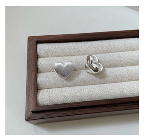 Close-up of S925 sterling silver heart earrings with brushed and polished finishes