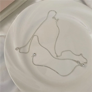 Minimalist S925 sterling silver heart tassel necklace on a white ceramic plate