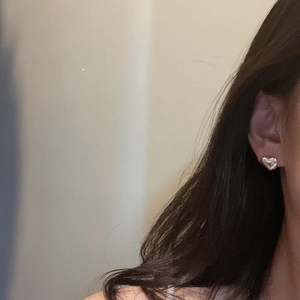 Minimalist S925 sterling silver heart-shaped stud earring shown on an ear lobe