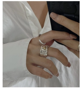 Close-up of retro wide silver ring with lava texture and gold heart detail