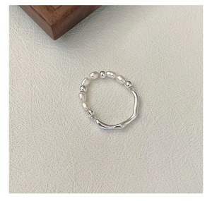 Dettaglio anello in argento S925 con perle irregolari e trama in metallo liquido