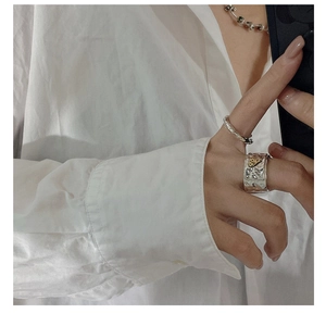 Detail of vintage silver S925 ring with textured surface and small gold heart element