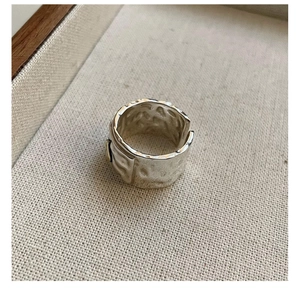 Detail of S925 sterling silver hammered wide band ring with vintage textured finish
