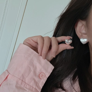 Minimalist S925 sterling silver heart-shaped hoop earrings with polished finish on model
