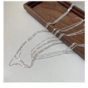 Detailed macro view of S925 sterling silver triple-layer necklace with flat lace chain links
