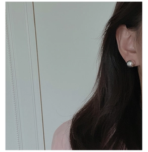 Close-up of 8mm sterling silver ball stud earring worn by a model for a minimalist look