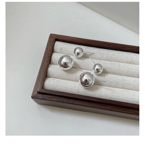 Detailed view of polished S925 sterling silver ball stud earrings in two sizes