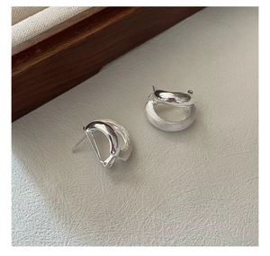 Detailed close-up of 925 sterling silver earrings showing polished and brushed textures