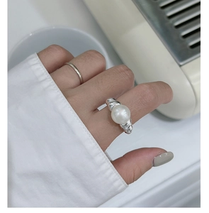 Macro detail of an S925 silver ring featuring a large pearl and textured croissant band