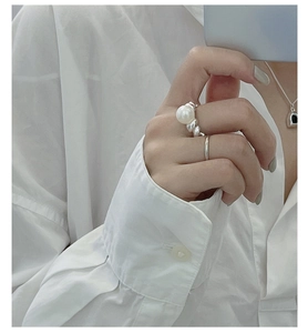 Detail of S925 silver croissant ring set with large pearl and slim band worn on finger