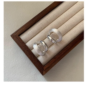 Detail of 925 sterling silver hoop earrings with brushed and polished finish in a box