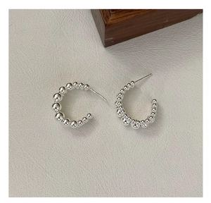 Detail view of S925 sterling silver beaded C-shaped earrings with hallmark engraving