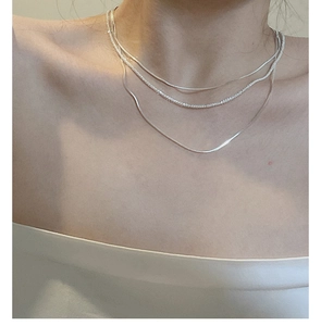Detail of S925 sterling silver triple layered necklace showing snake and bead chain textures