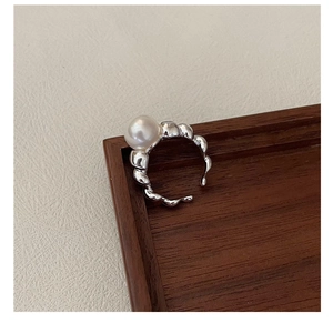 Macro view of S925 sterling silver ring with large pearl and irregular wavy metal band