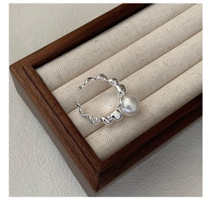 Macro shot of S925 silver croissant ring with large pearl in luxury display box