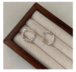 Detailed macro view of S925 sterling silver hoop earrings with hammered texture finish