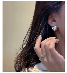 S925 sterling silver heart earrings and delicate pearl ring worn on model closeup