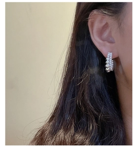 Detail of S925 sterling silver double-layer beaded hoop earrings with textured finish