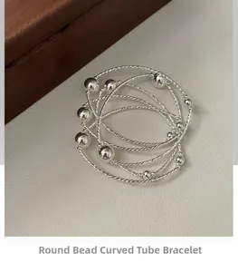 Macro detail of S925 sterling silver multilayer beaded bracelet with curved metal tubes