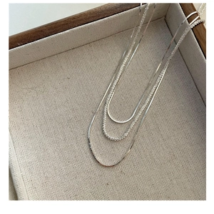 Detailed close-up of layered S925 sterling silver snake and twisted rope texture chains