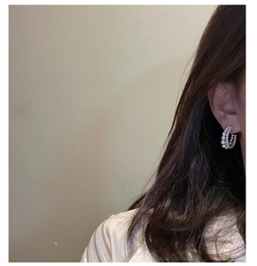 Detail of S925 sterling silver double-layered beaded hoop earrings worn on ear