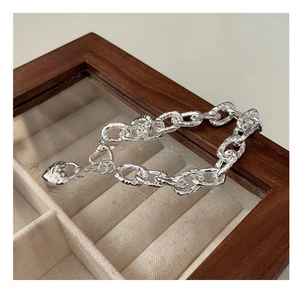 Dettaglio del bracciale a catena pesante in argento S925 con cuore e trama martellata