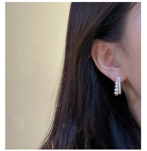 Close-up of S925 sterling silver double-layered beaded hoop earrings worn on ear