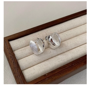 Detailed close-up of S925 silver hoop earrings with a brushed and polished finish