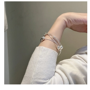 Detail of S925 sterling silver multi-layer intertwined bracelet with polished beads on wrist
