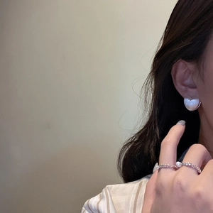 Elegant S925 sterling silver heart earrings and pearl ring worn by a model