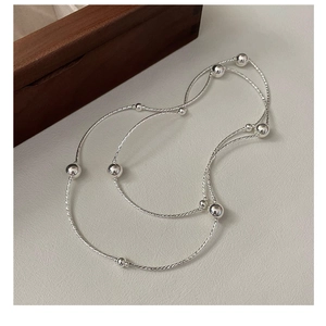 Macro detail of S925 sterling silver multilayer beaded chain with twisted metal texture